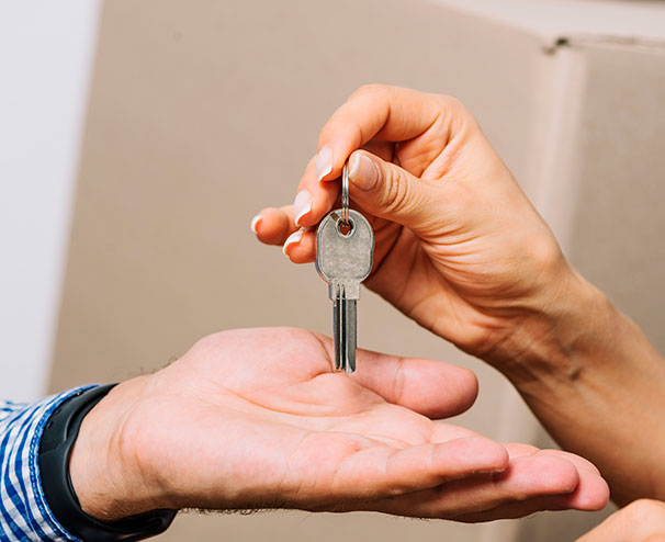 Imagem de uma pessoa entregando a chave a outra pessoa após a conclusão de um projeto turn key